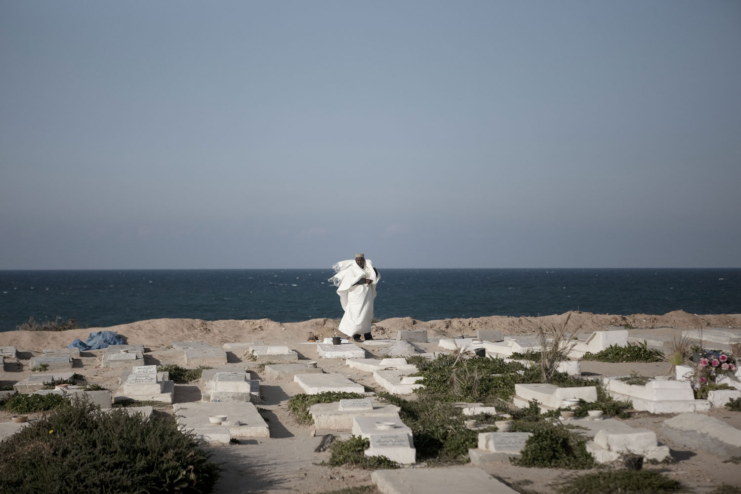 Christopher Morris. From  Theater and War.  Published on LightBox, April 8, 2011.
                              A man watches a funeral procession at Martyrs Cemetery in Tripoli, March 24, 2011.