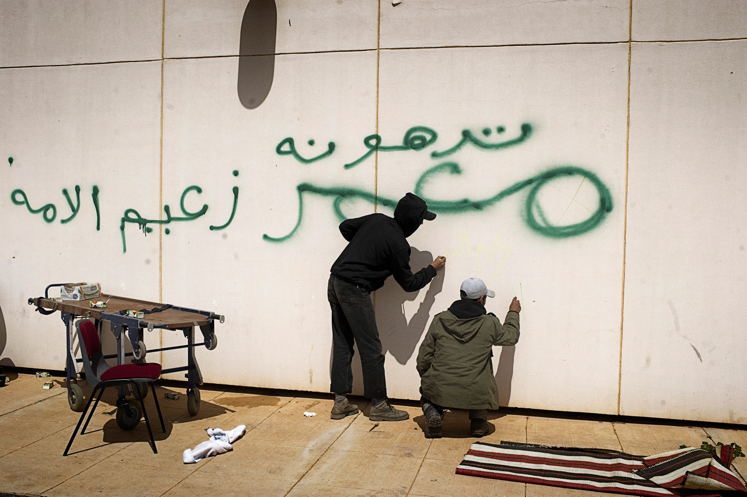 Ras Lanuf, Libya — March 27, 2011
                              Rebels scribble over Gaddafi loyalists' graffiti (in green) near a hospital.
