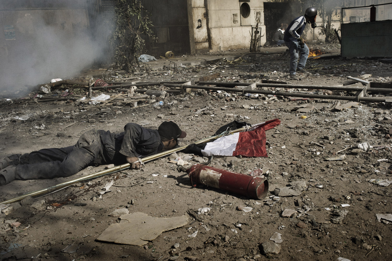 A protester crouches for cover during clashes with Egyptian security forces, November 23, 2011.
