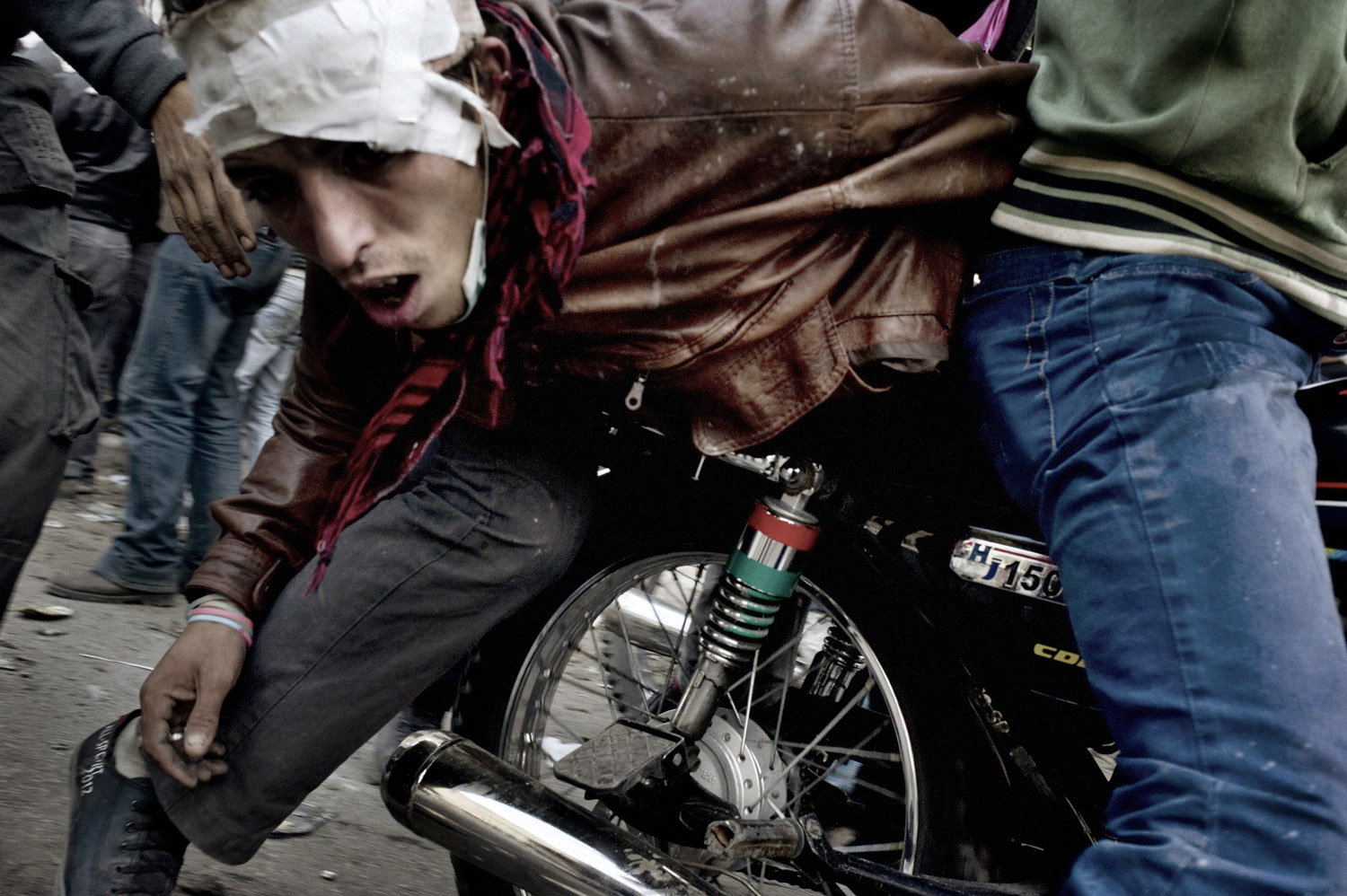 A wounded protester is evacuated on the back of a motorcycle, November 23, 2011.