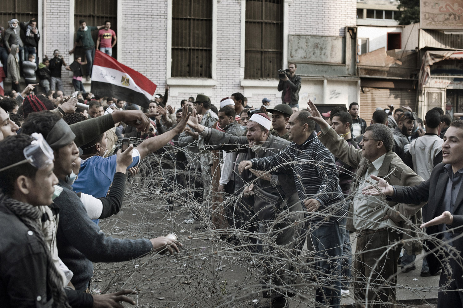 Protesters separated by barb wire argue with one another during a lull in clashes, November 23, 2011.