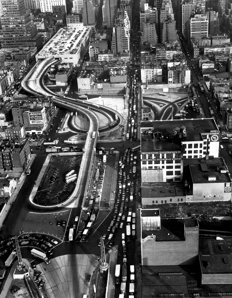 An aerial view of the entrance ramp leading to the top of the Port Authority Bus Terminal against the skyline of New York City in 1950.