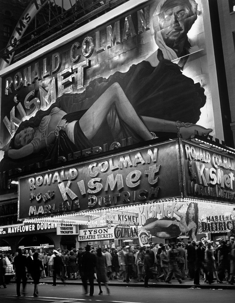 New Yorkers crowd Broadway below a large billboard depicting actress Marlene Dietrich in October 1944.