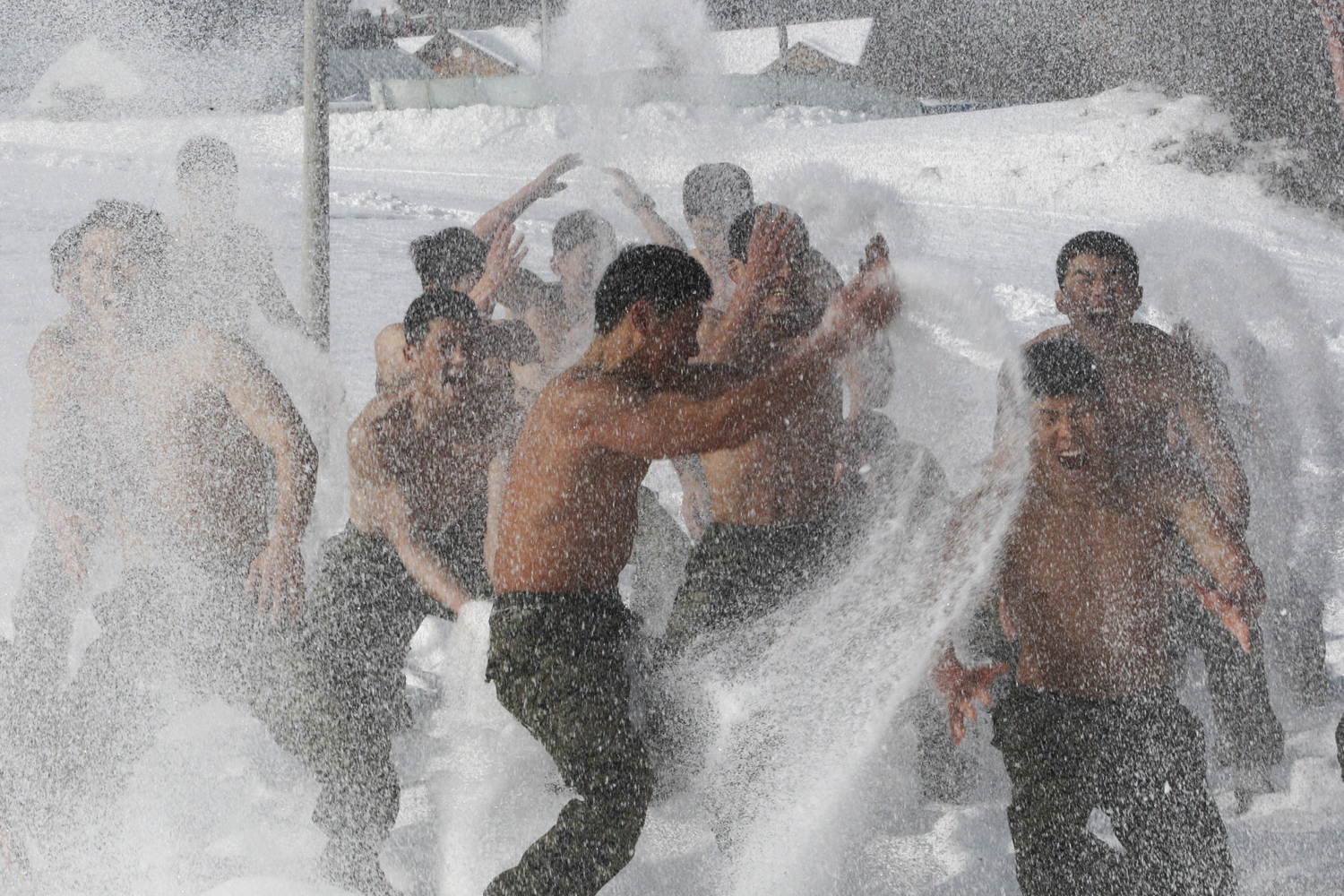 January 11, 2012. Half-naked South Korean Special Warfare Forces members hurl snow during a winter exercise in Pyeongchang, South Korea. More than 200 soldiers participated in the one-month winter exercise.