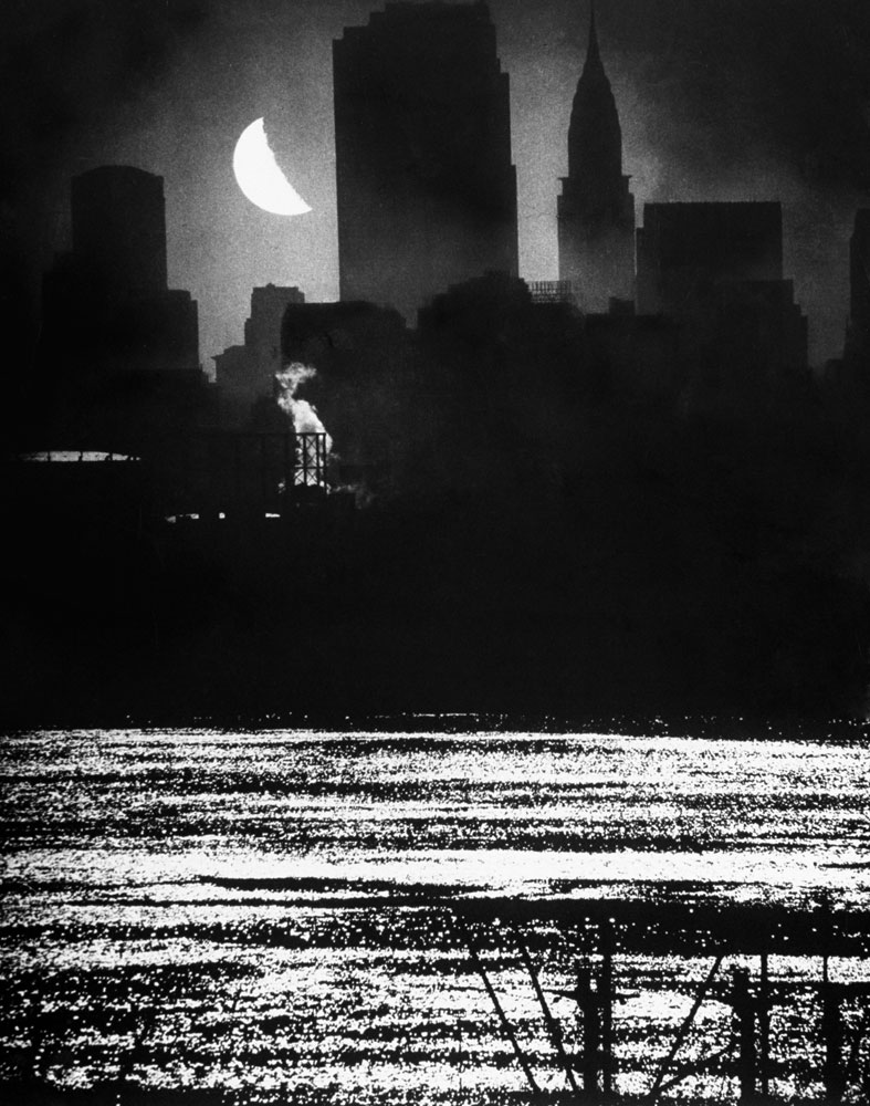 A view from New Jersey of the moon shining over Manhattan's RCA and Chrysler buildings as its light shimmers on the waters of the Hudson River in September 1946.