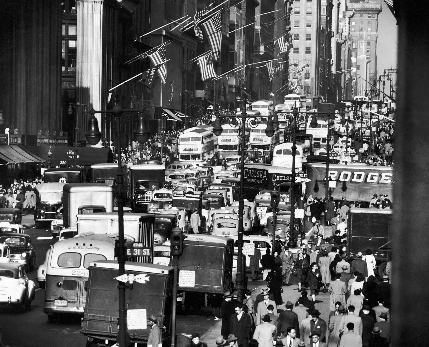 Pre-Christmas holiday traffic teaming with double-decker buses, trucks and cars, crawling along two-way-laned, 5th avenue near 34th street in November 1948.