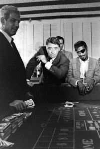 Peter Lawford plays gambles in Las Vegas with Sammy Davis Jr. in 1962. Sammy Davis Jr is wearing an eye patch.
