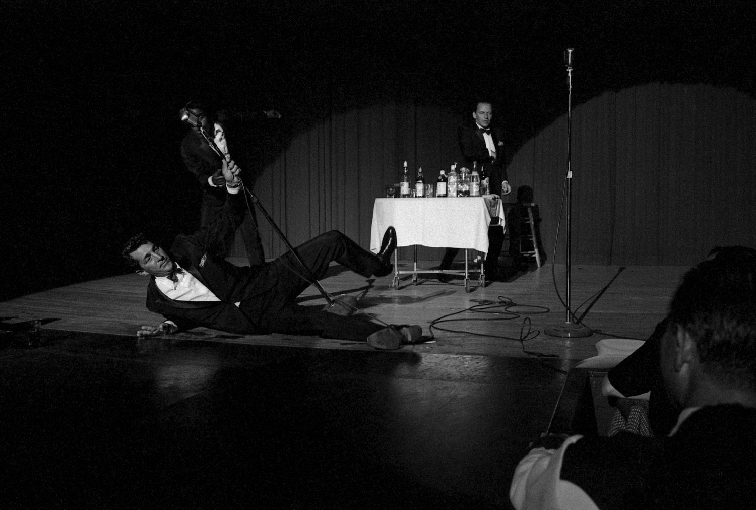 Dean Martin, Sammy Davis Jr., and Frank Sinatra pretend to be drunk on stage for a charity event in 1960.