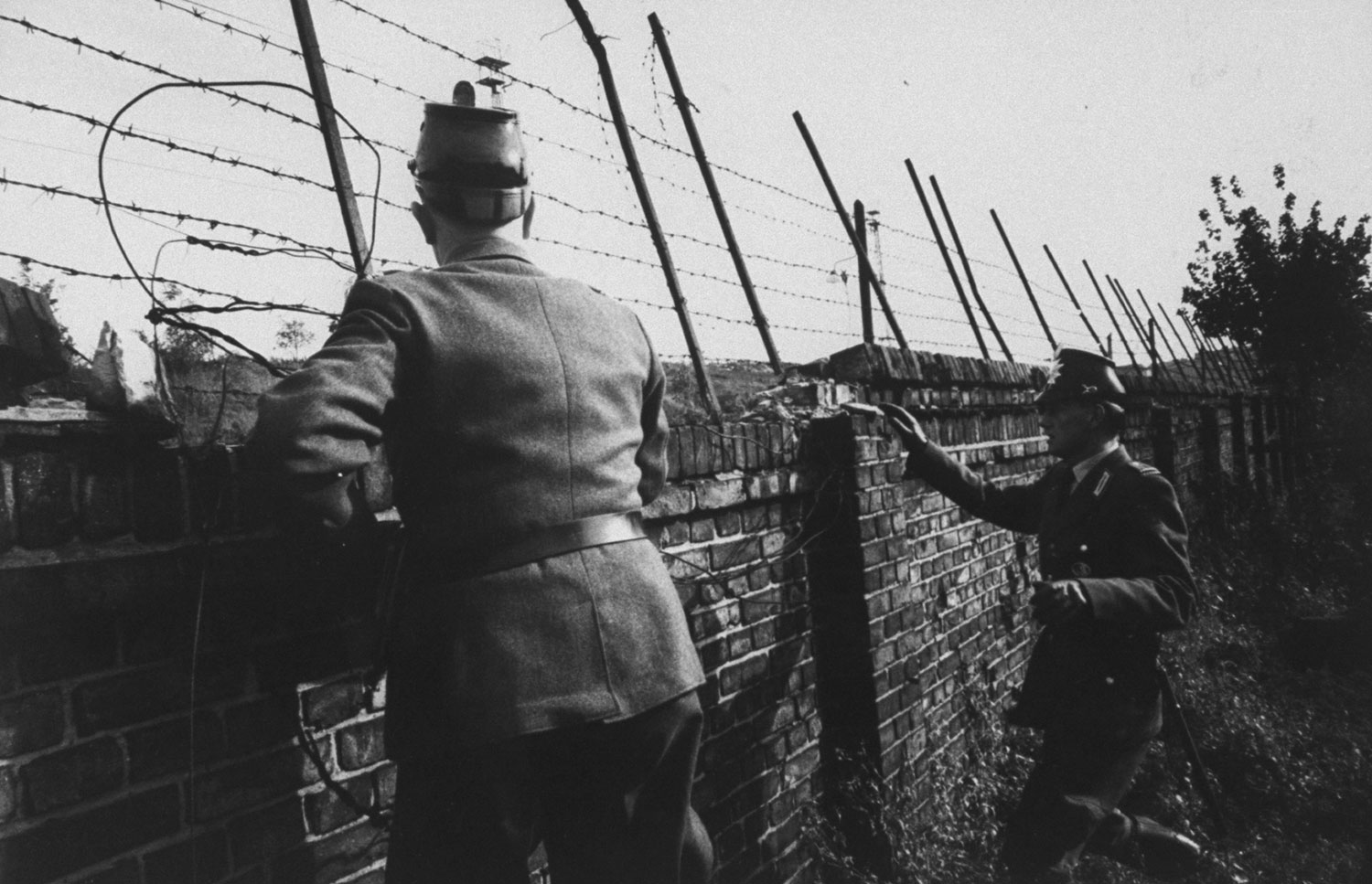 West German police look out over the Berlin Wall for potential escapees to the West