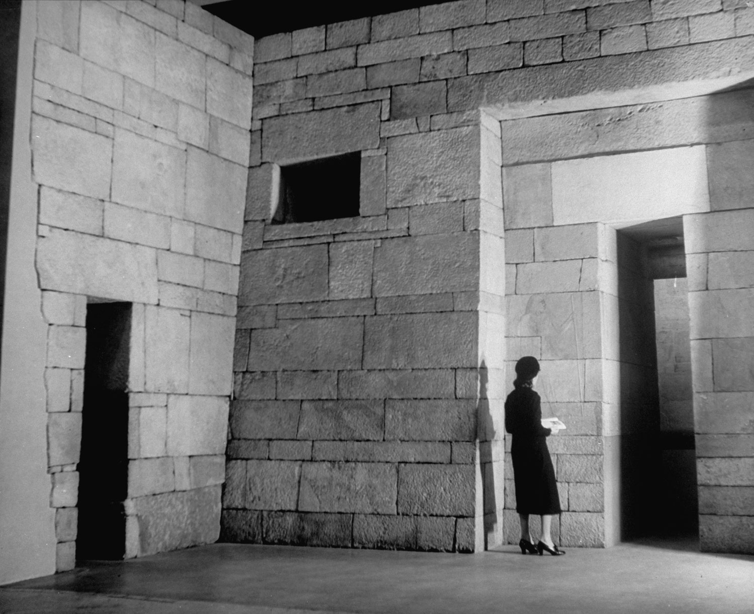 A lone woman stands at the threshold to an Egyptian Tomb at the Metropolitian Museum of Art