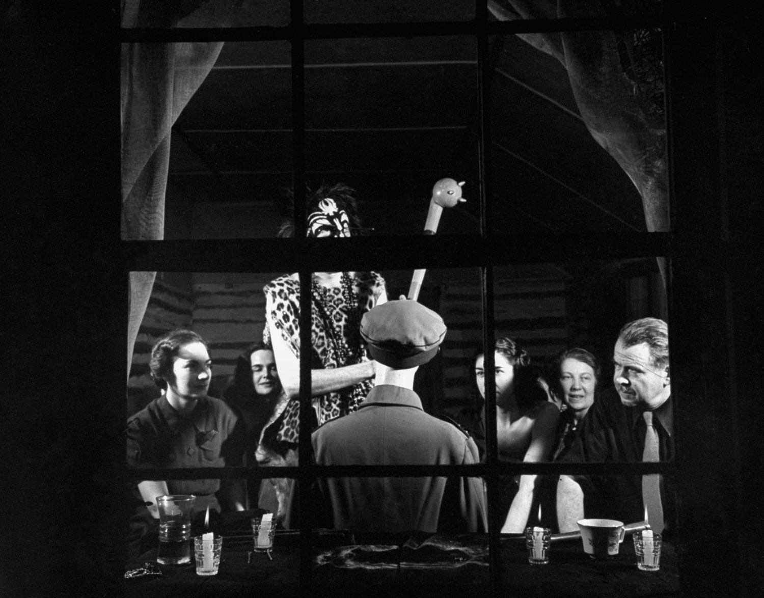 Chief hexer Ted Caldwell intones an incantation. On the right, in dark shirt and tie, is author William Seabrook. Hitler's effigy sits with its back to the window.