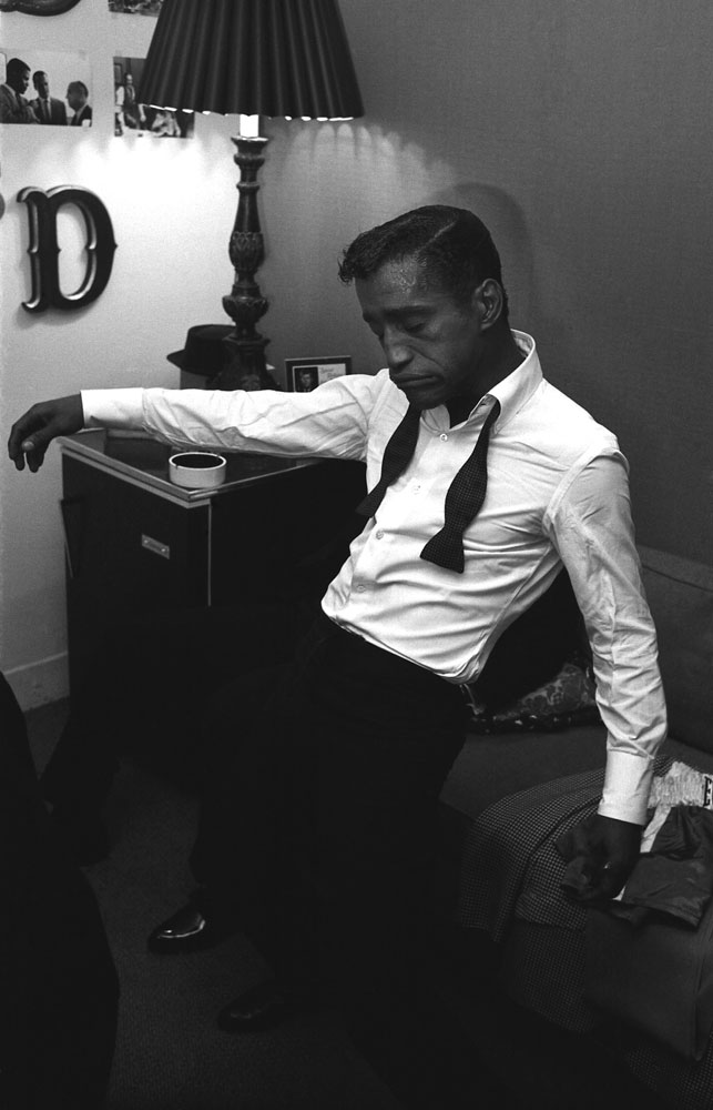 Sammy Davis Jr. clowns backstage during Golden Boy's run in 1964. He bowtie is untied and his eyes are closed.