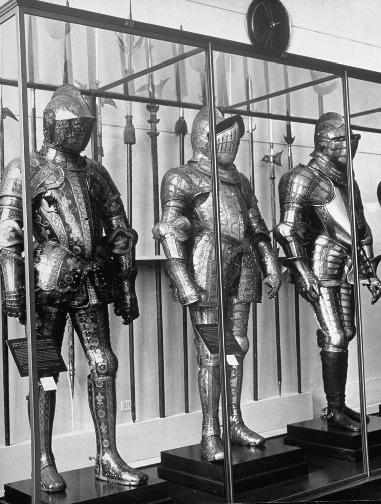 Glass cases display three, highly-detailed, full suits of armor at the Metropolitan Museum of Art.