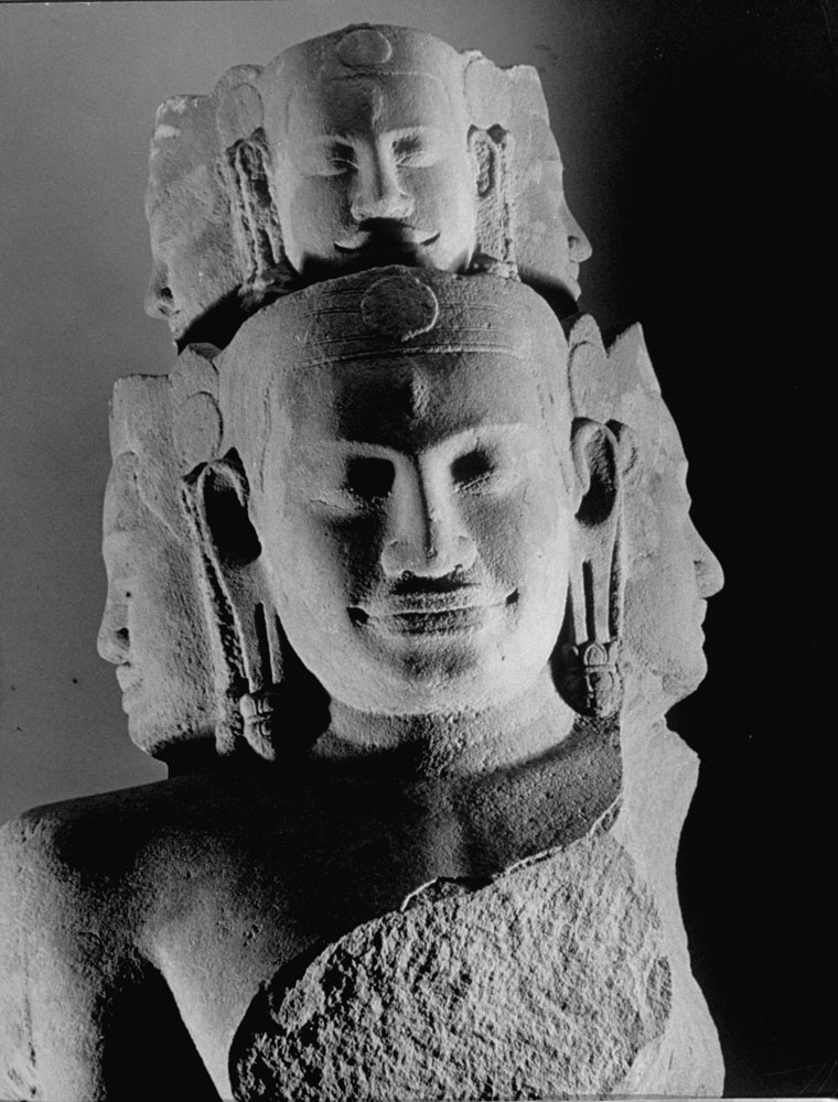A multi-faced stone statue from Asia is displayed at the Metropolitan Museum of Art.