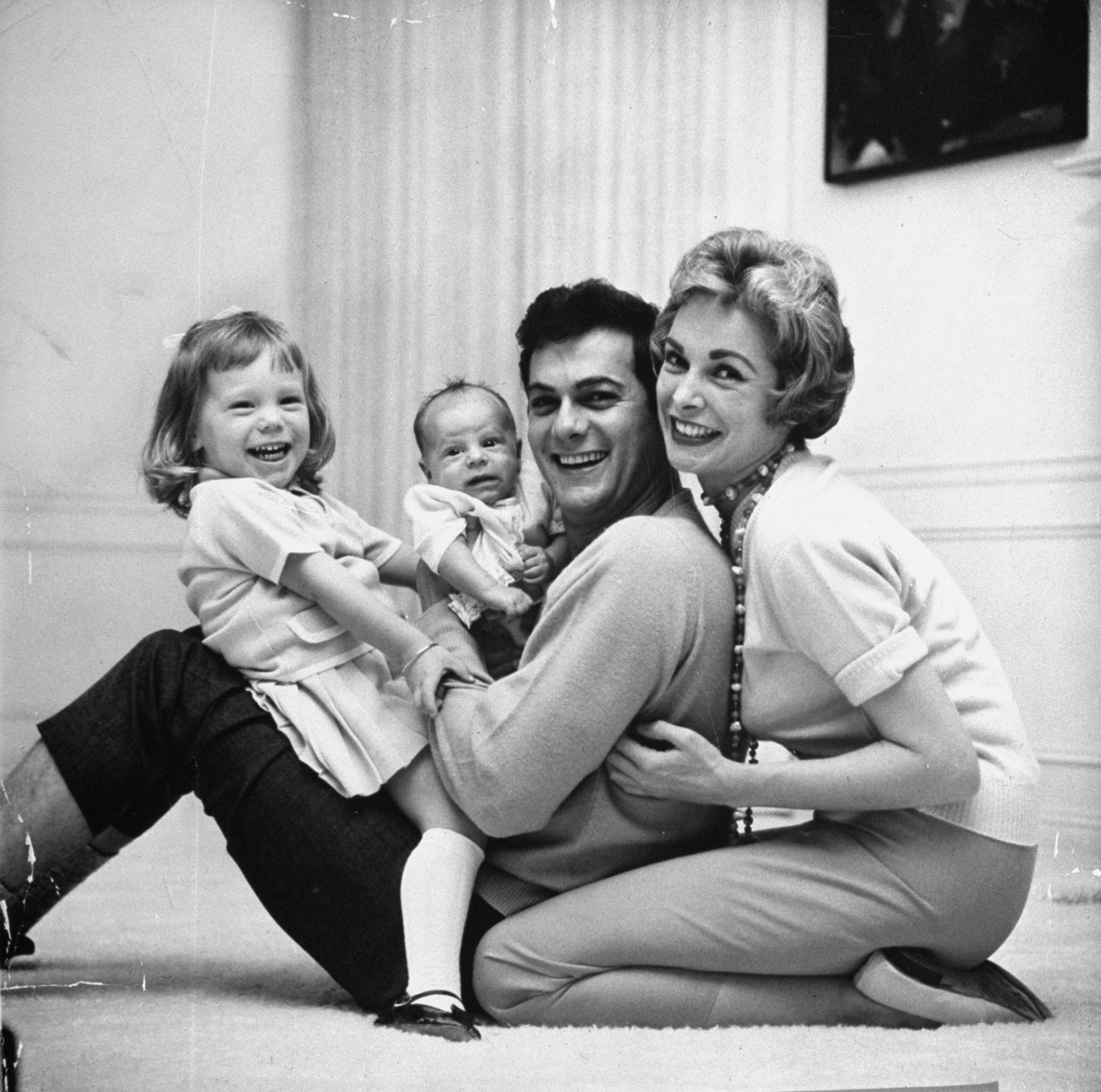Tony Curtis and wife Janet Leigh play with daughters Kelly and Jamie Lee on floor of Beverly Hills home in 1959