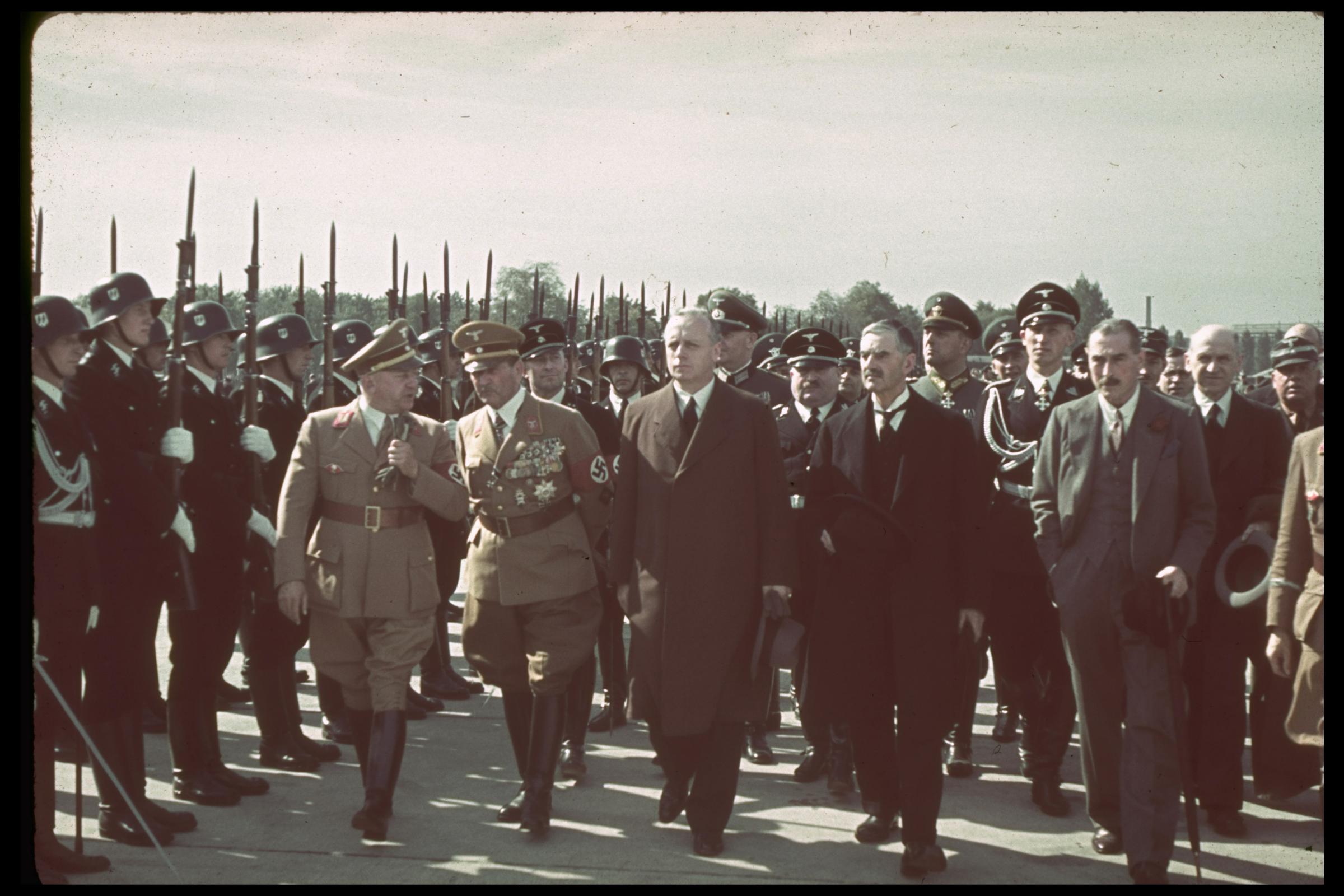 British Prime Minister Neville Chamberlain (front row, second from right) walks past a Nazi honor guard on the way to a meeting with Adolf Hitler in 1938.