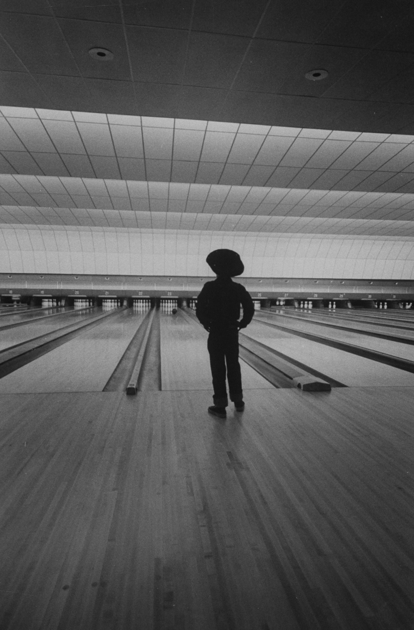 A bowler watches his ball approach the pins.