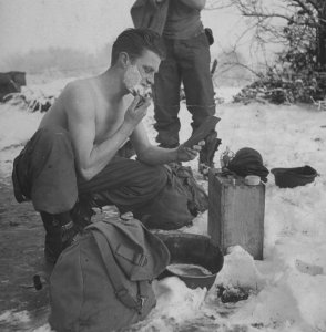 A soldier shaves during a lull in battle in the Ardennes Forest in December 1944.