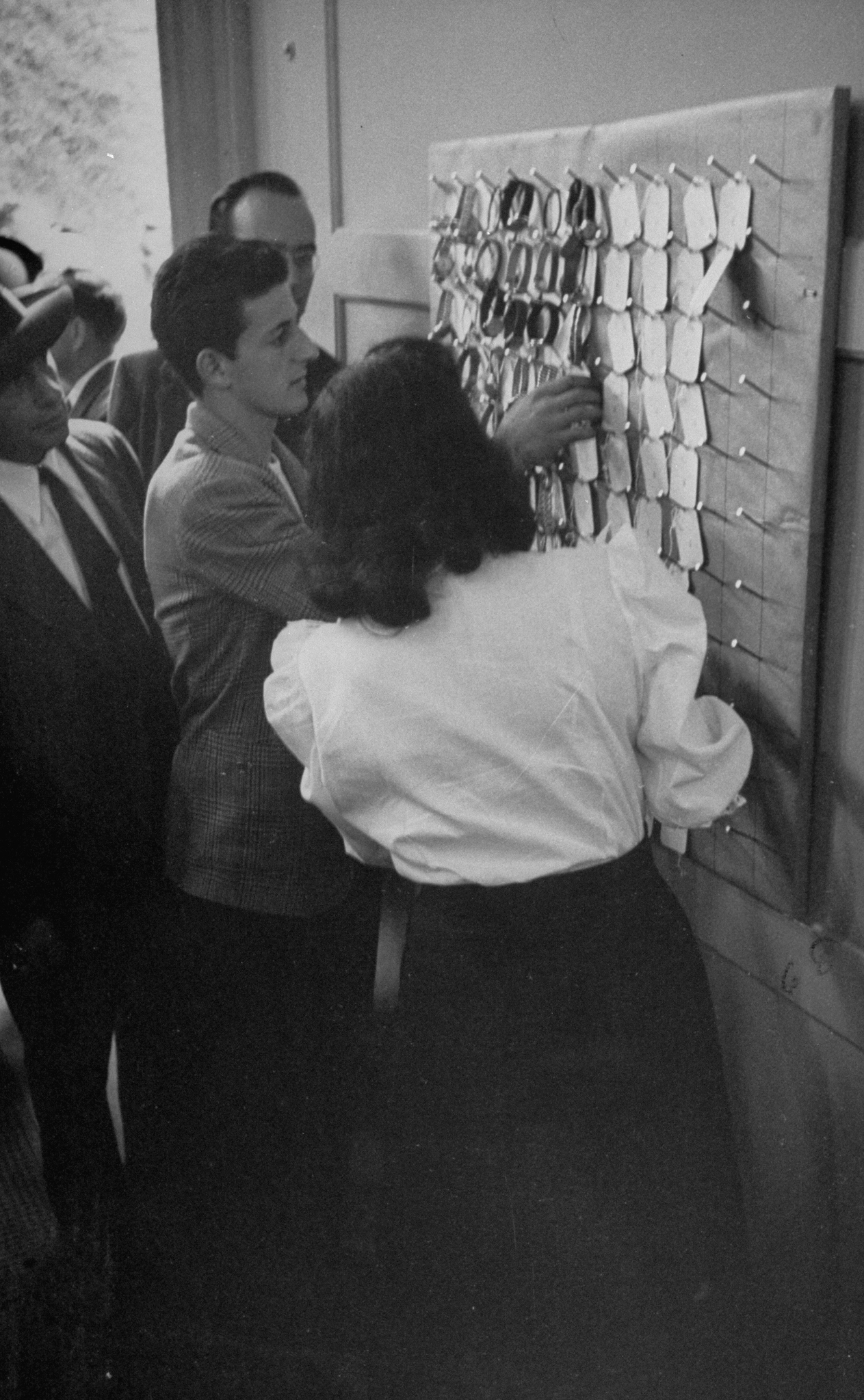 Before entering the christening ceremonies for Columbia University's cyclotron in 1948, guests check their watches to guard against the machine's enormous magnetic pull.