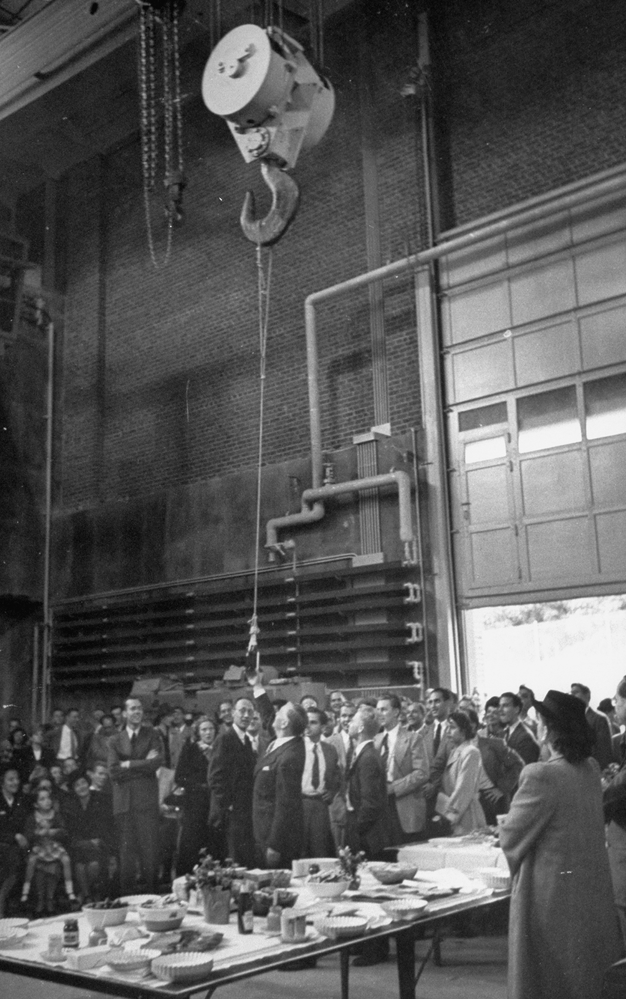 A bottle of champagne is delivered by crane for use in the christening of Columbia's cyclotron in 1948.