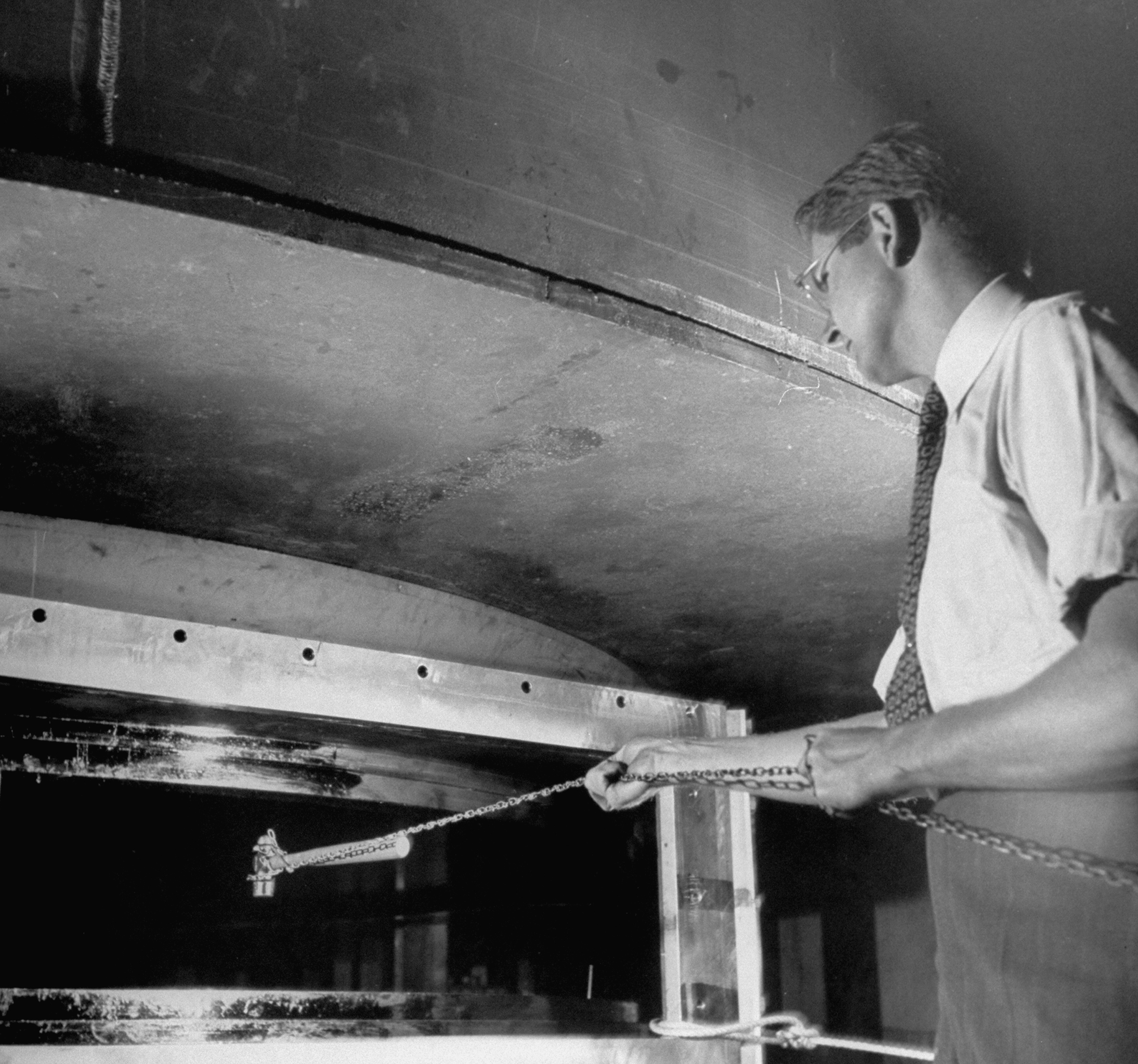 A scientist holds a chain attached to a hammer to demonstrate the magnetic power of the cyclotron (an early atom smasher) at Columbia University's Nevis Lab in Irvington, New York, in 1948.