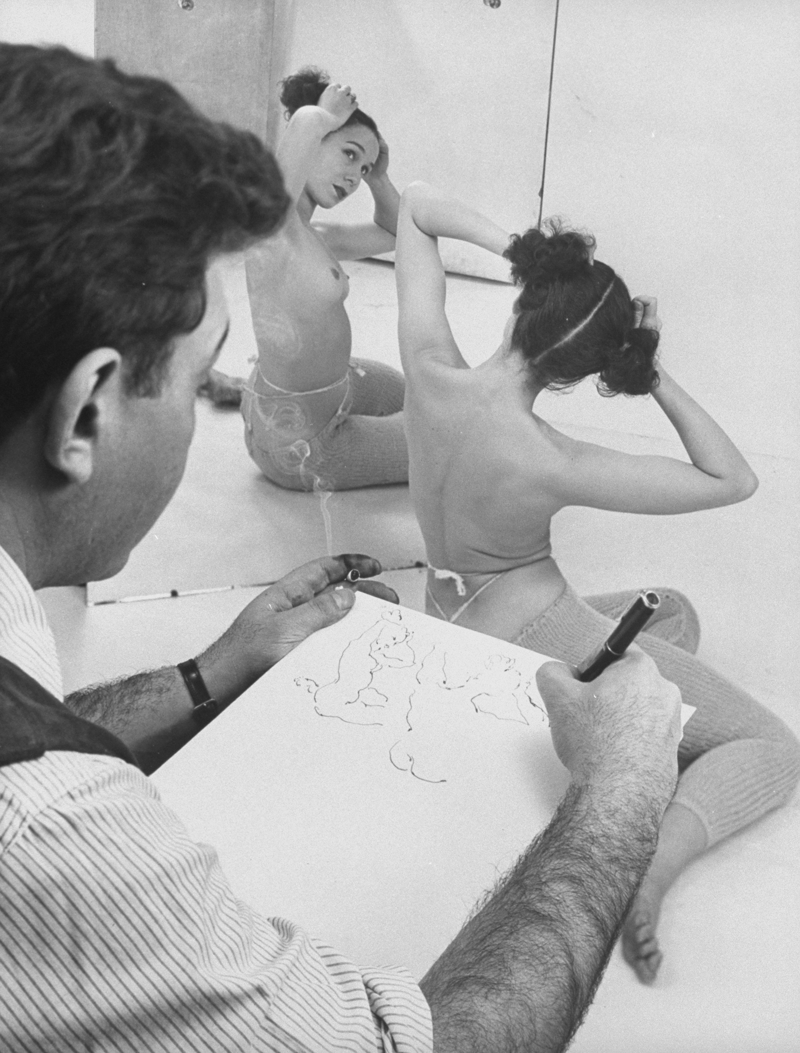 Artist David Fredenthal (1914 - 1958) sketches a model.