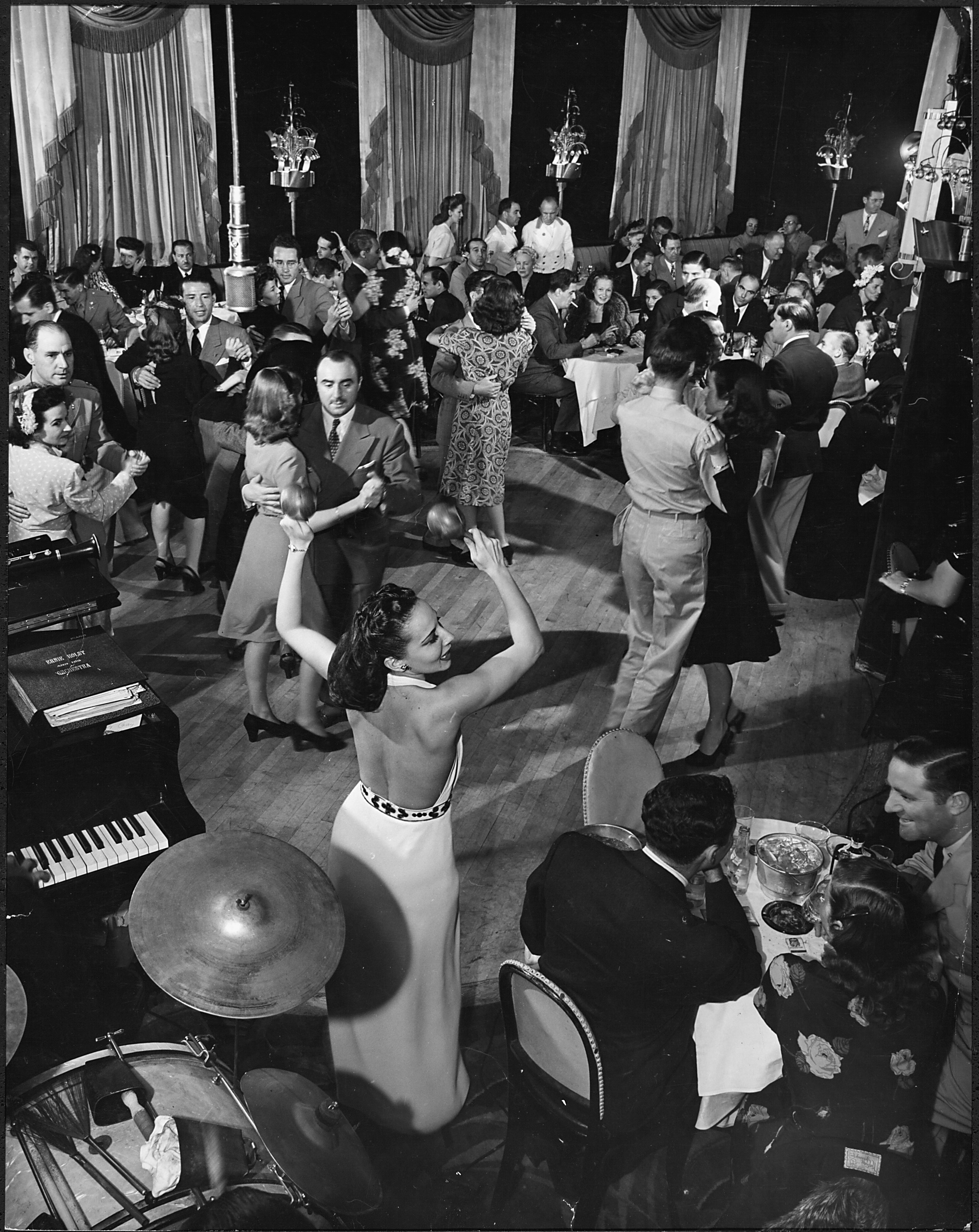 Patrons dine and dance to Ecita (with maracas in the air) and her orchestra in the Stork Club dining room in 1944.