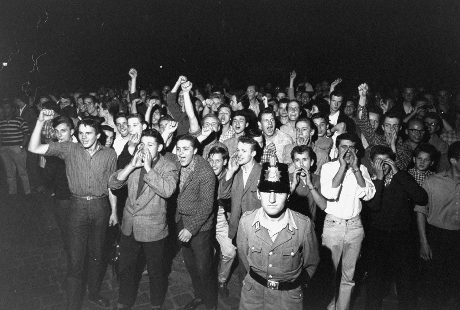 A crowd of jeering West Berlin youths protests the newly constructed Wall