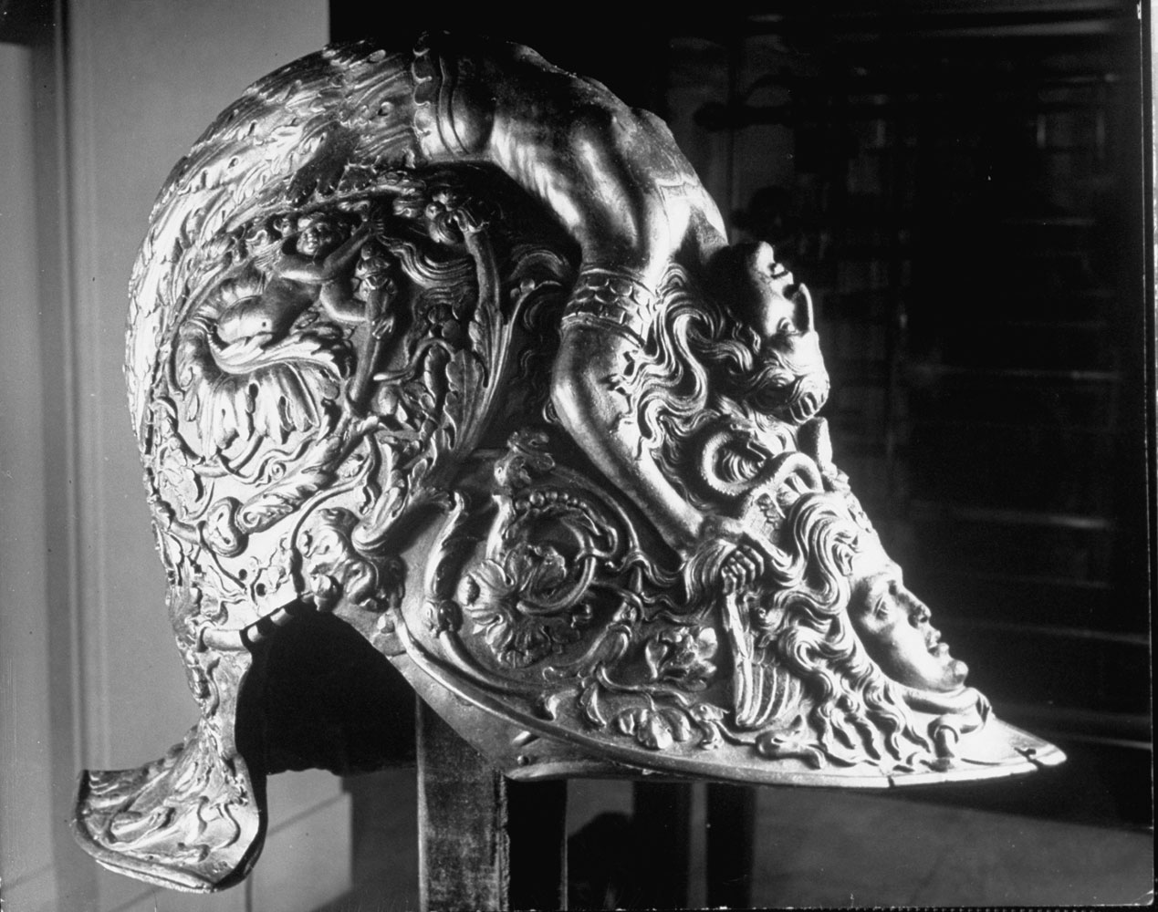 An ornate helmet adorned with semi-nude figures sits in the collection of the Metropolitan Museum of Art.