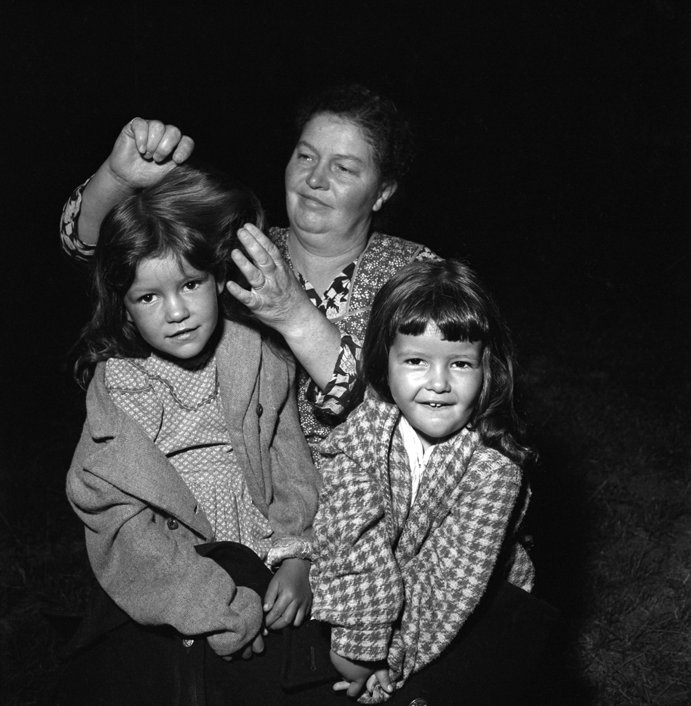 Short Creek raid, Arizona, 1953. Shortly after authorities descended, a woman combs a little girl's hair in the predawn darkness at Short Creek.