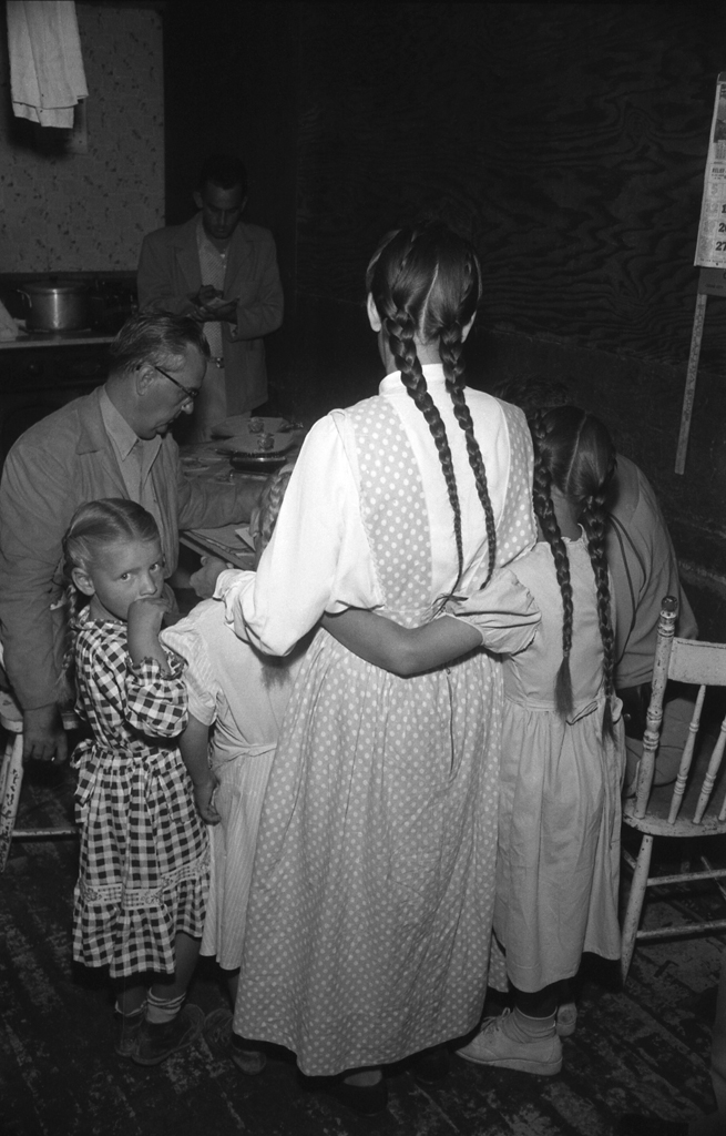Short Creek raid, Arizona, 1953. Her daughters clinging to her, a woman identified as Mrs. John Barlow faces questioning from Attorney General Ross Jones (seated).