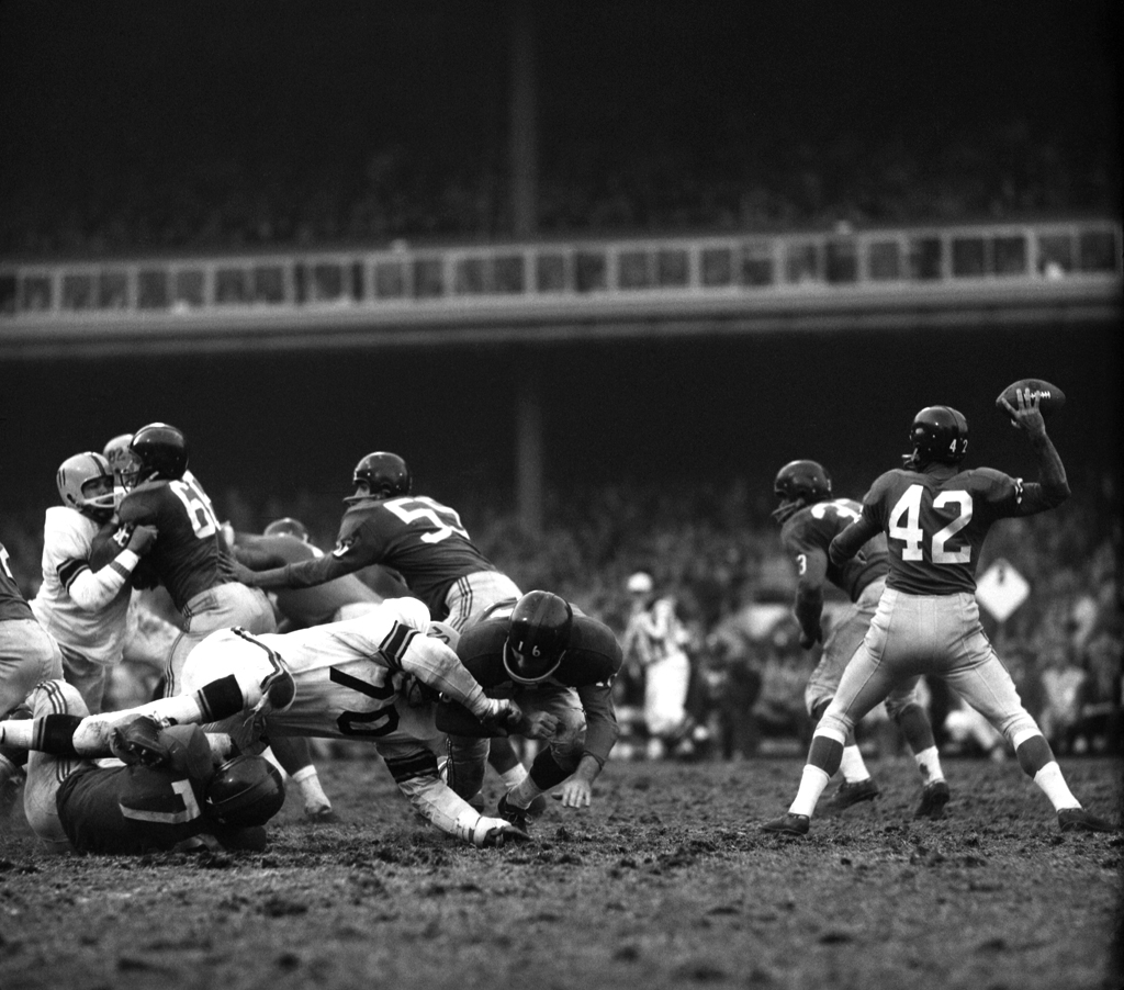 New York Giants quarterback Charlie Conerly drops back to pass during a game against the Steelers, 1960.