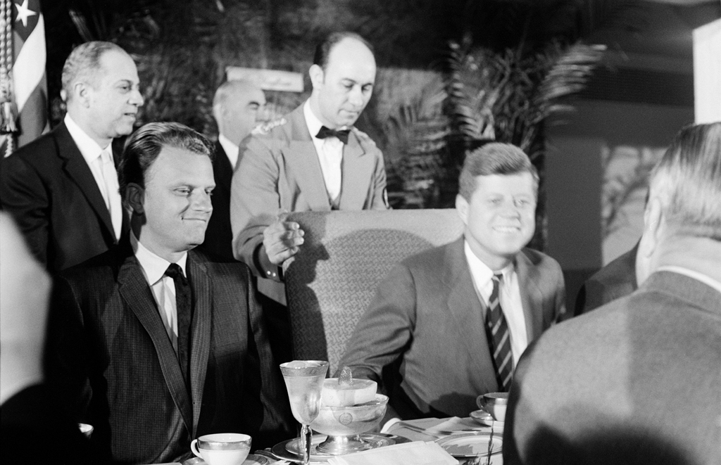 Billy Graham joins newly inaugurated president John F. Kennedy at a national prayer breakfast at Washington's Mayflower Hotel in February 1961.