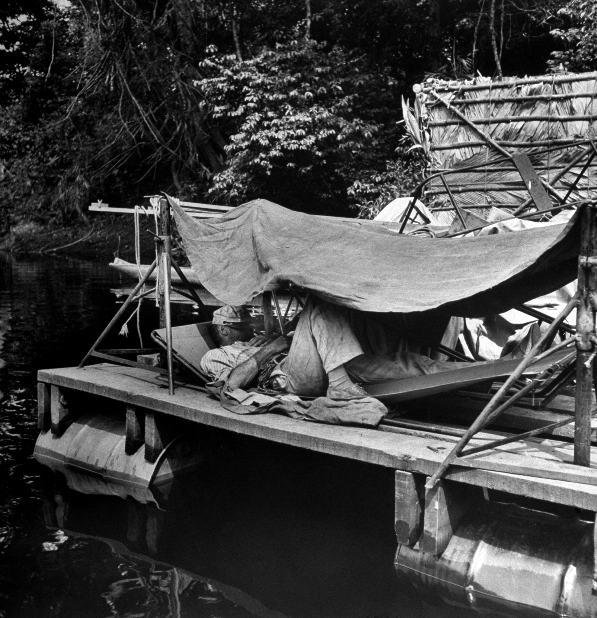 "Bogart snoozes in a hammock under makeshift shelter on an equipment raft. He never had to study lines, learned them after two or three readings."