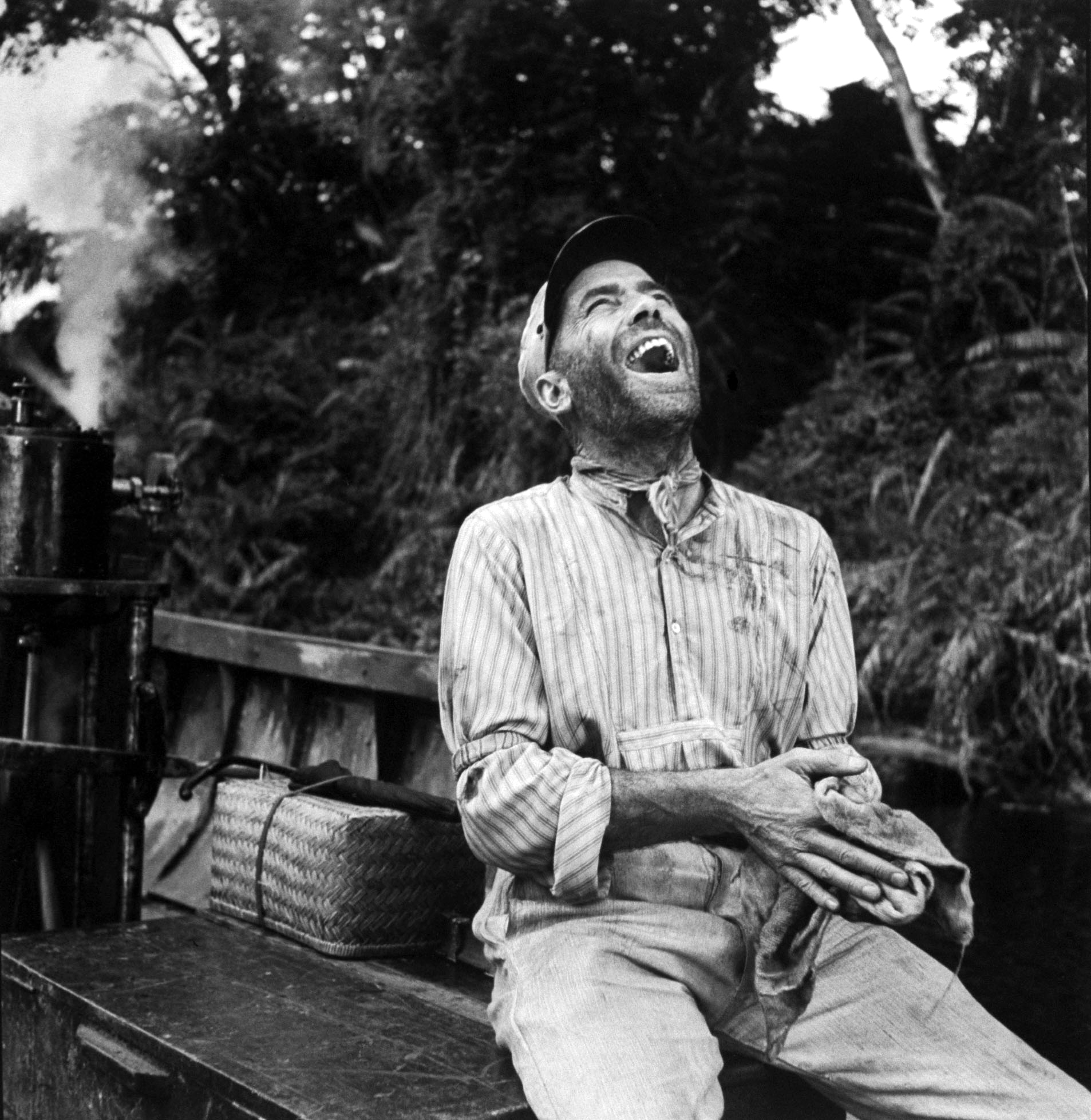A deeply amused Humphrey Bogart on location in Africa for the filming of The African Queen.