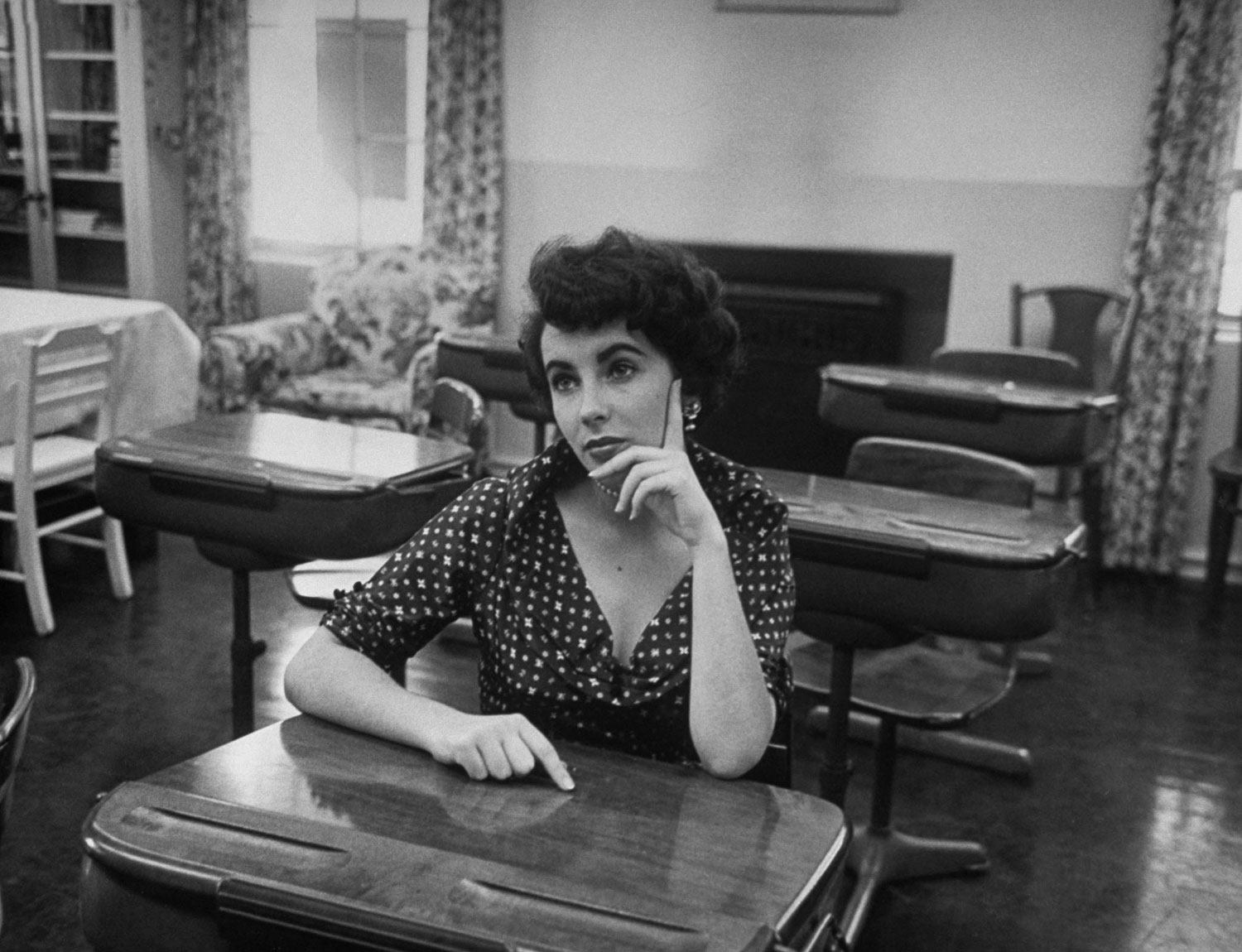 Elizabeth Taylor sits at a desk in a classroom at Hollywood's University High School in 1950.