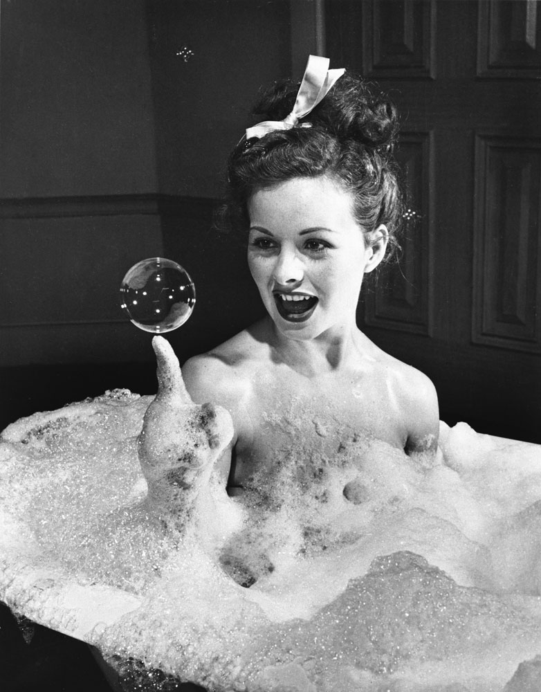 Actress Jeanne Crain balances a soap bubble on her index finger as she luxuriates in a bubble bath in a scene from the 1946 movie, Margie.