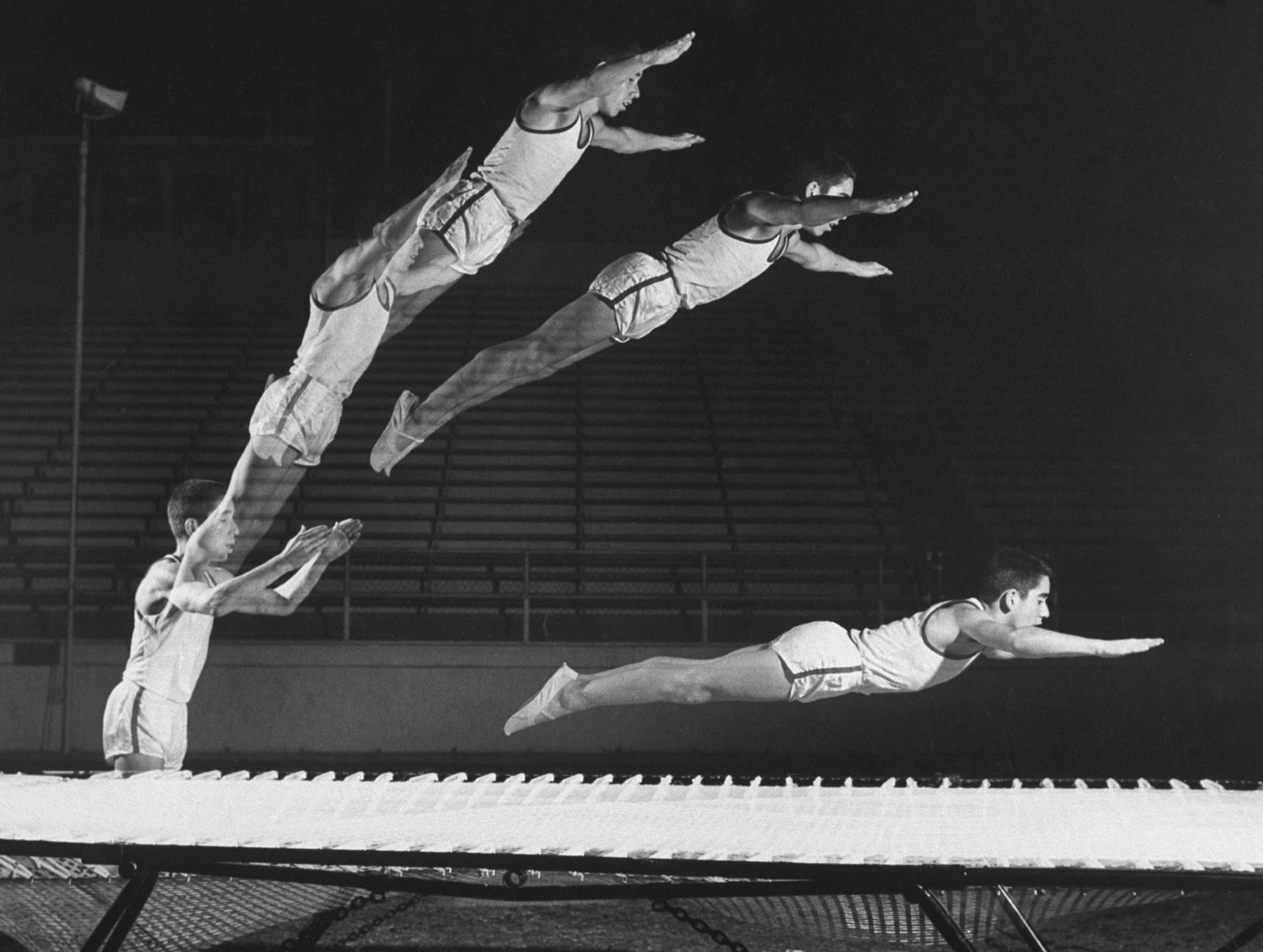 A multiple exposure shot of a gymnast jumping on a trampoline in 1960.