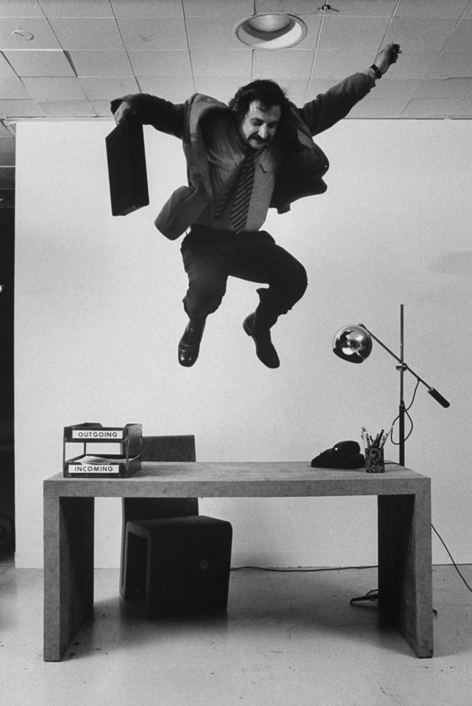 Frank Gehry jumps on a desk — part of his line of cardboard furniture — in 1972.