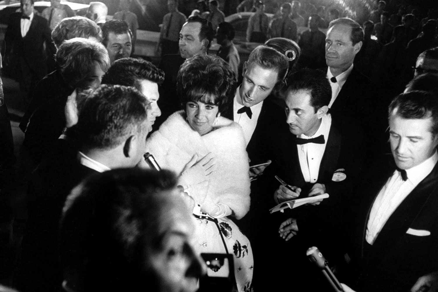 Elizabeth Taylor walks through a crowd of admirers at the Oscars in 1961.
