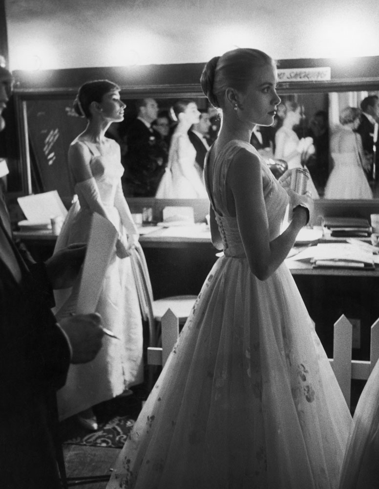 Audrey Hepburn and Grace Kelly wait backstage at the RKO Pantages Theatre during the 1956 Academy Awards.