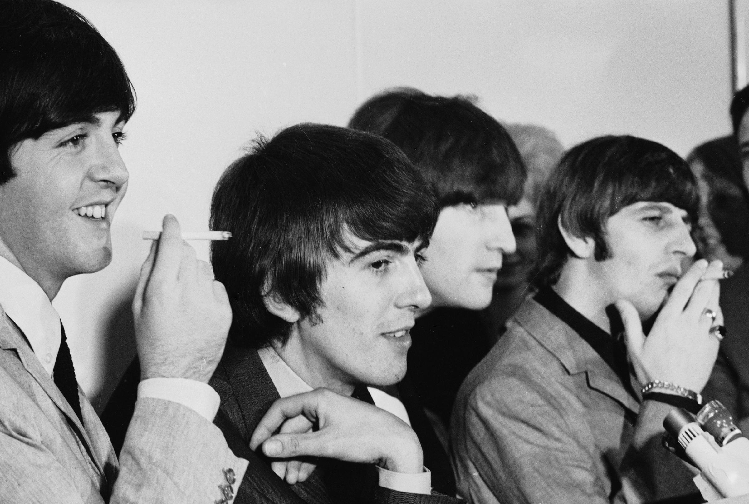 The Beatles joke and smoke at a press date in August 1964.