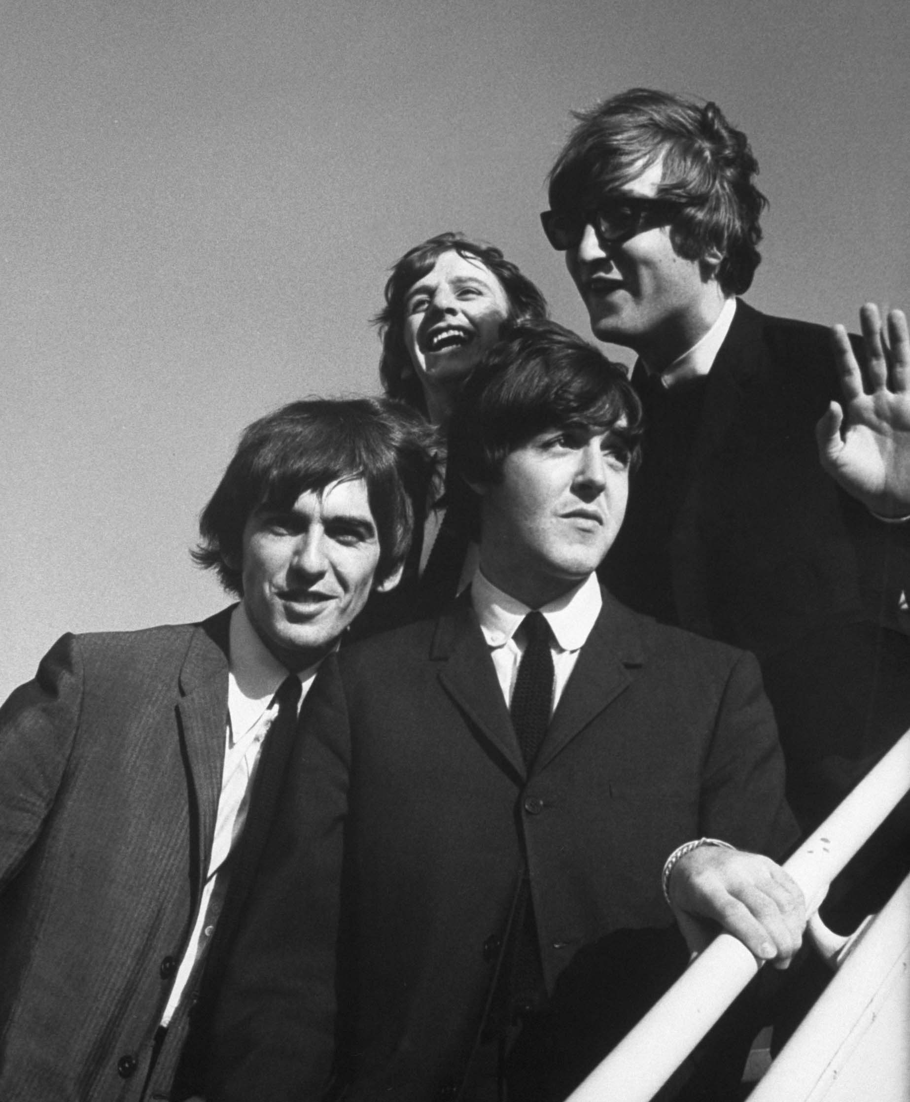 The Beatles wave to fans as they arrive at the Los Angeles airport in August 1964 for a press conference at the start of their second American tour.