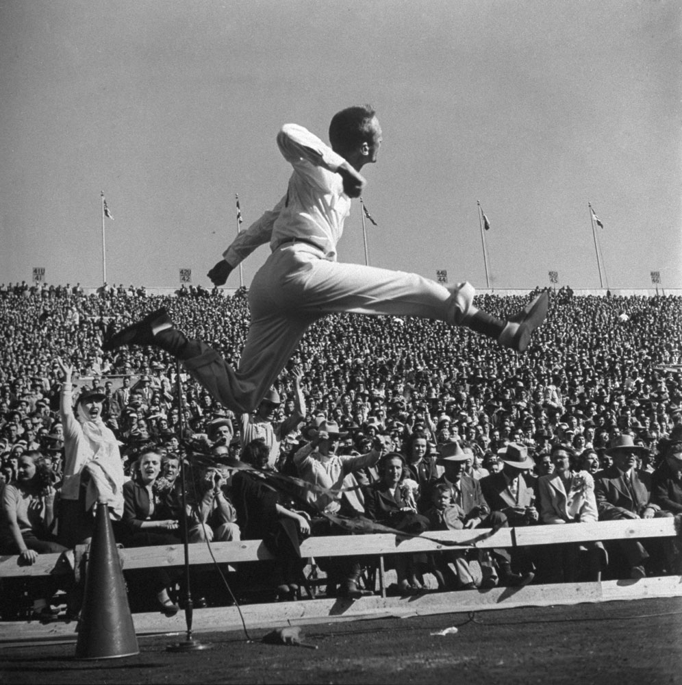 An SMU cheerleader takes to the air at a University of Texas football game in 1950.