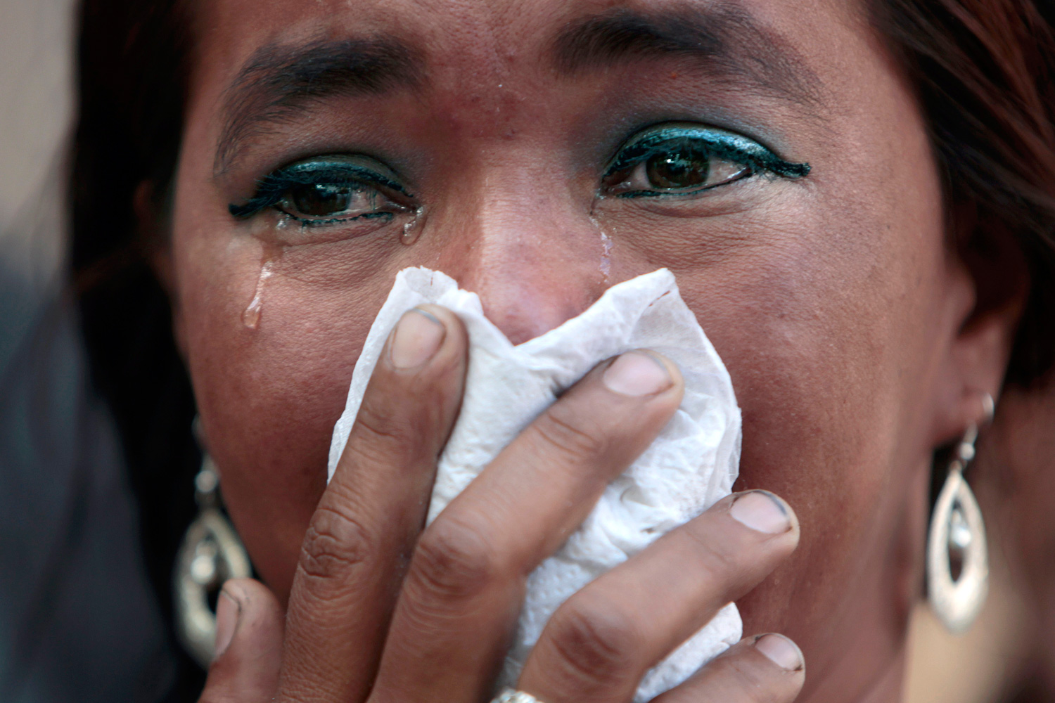 Feb. 20, 2012. A woman, relative of an inmate killed during last week's prison fire, cries while she and others inspect bodies looking for relatives at the morgue in Tegucigalpa, Honduras.