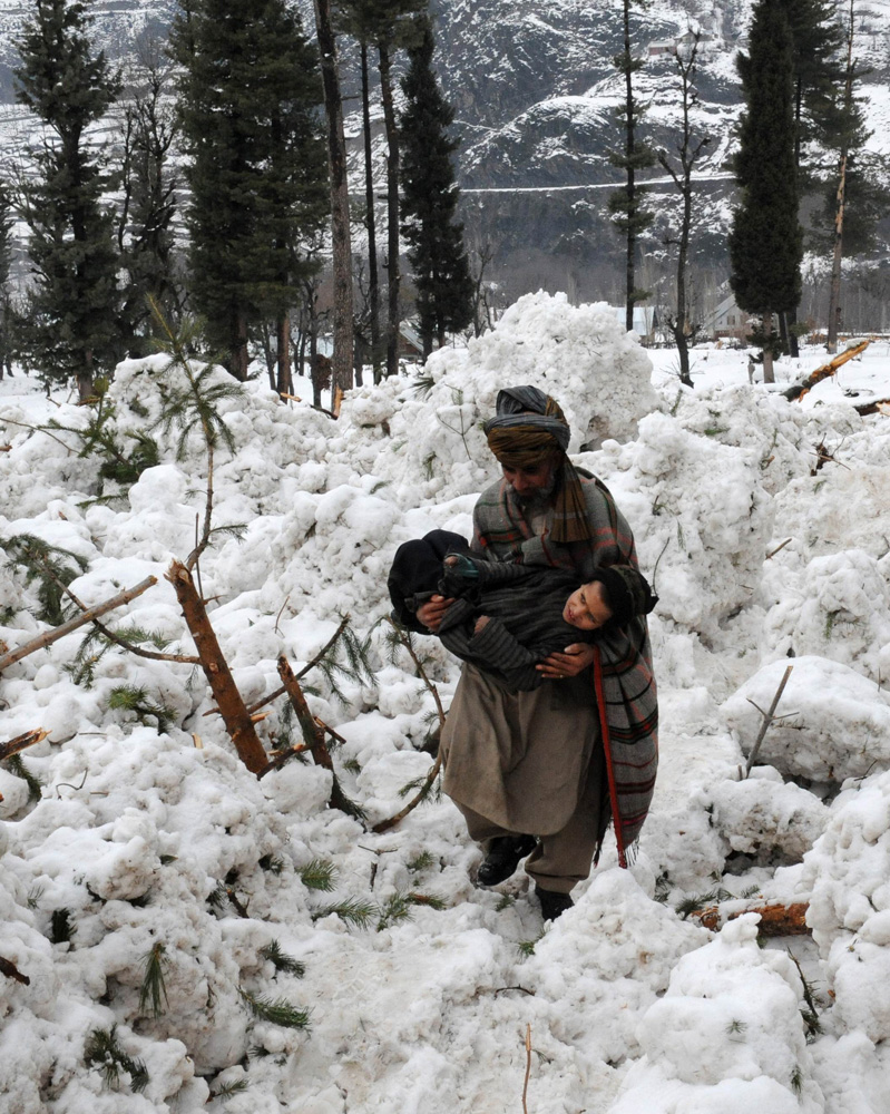 Feb. 23, 2012. A Kashmiri villager holds a relative after their huts were buried under snow due to an avalanche at Ramwari, about 70 km (43 miles) from Srinagar, India.