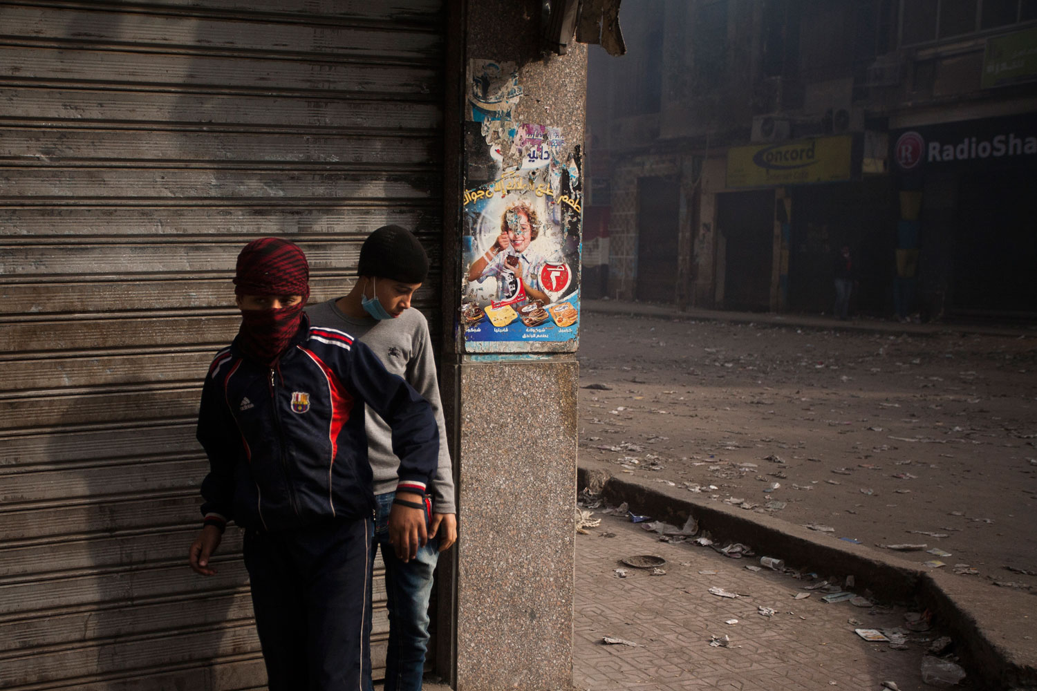 Two boys take positions behind a wall during street clashes on Mohamed Mahmoud street next to Tahrir Square.