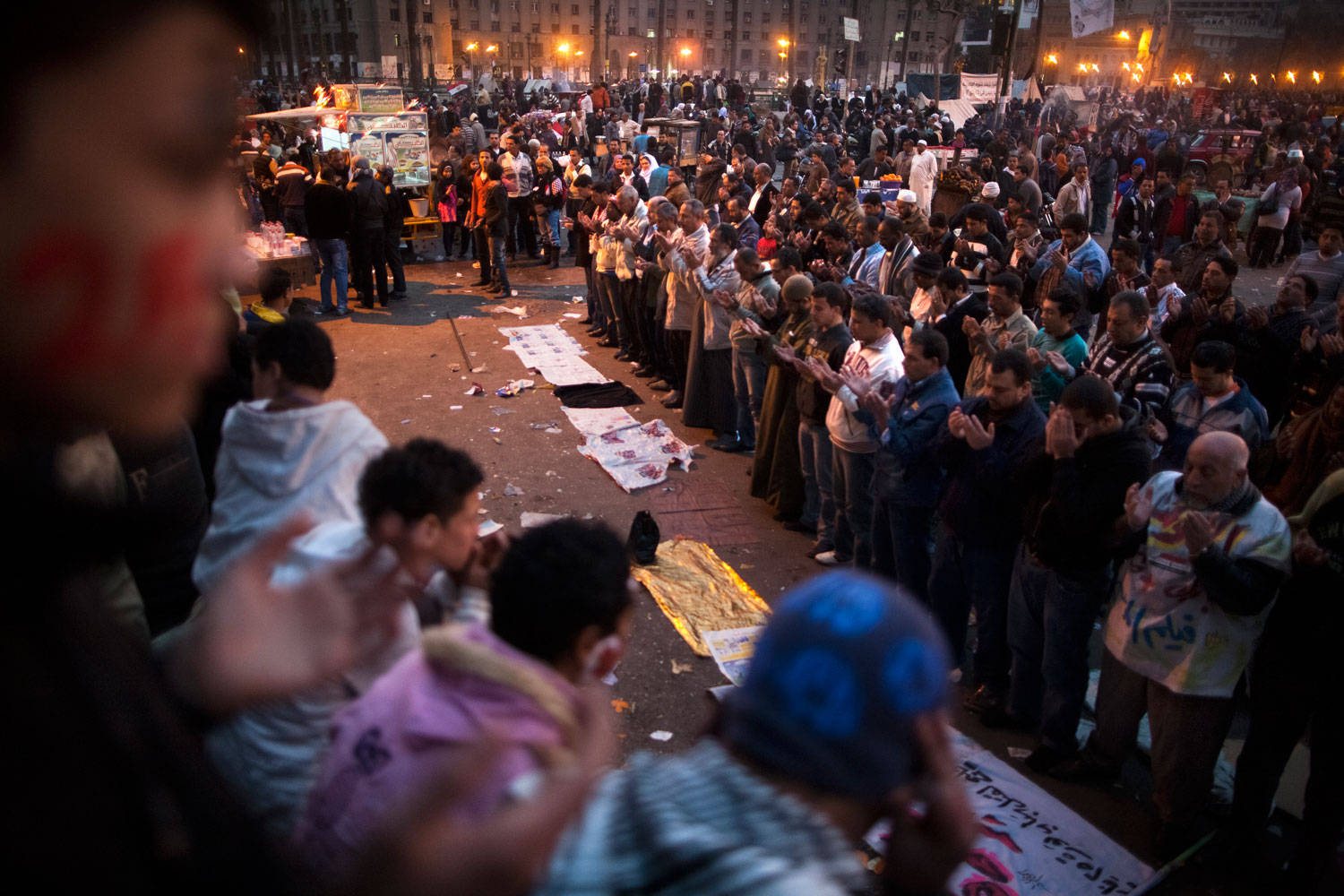 Egyptian youths watch and pray along with a large group of Egyptians after speeches in Tahrir Square.