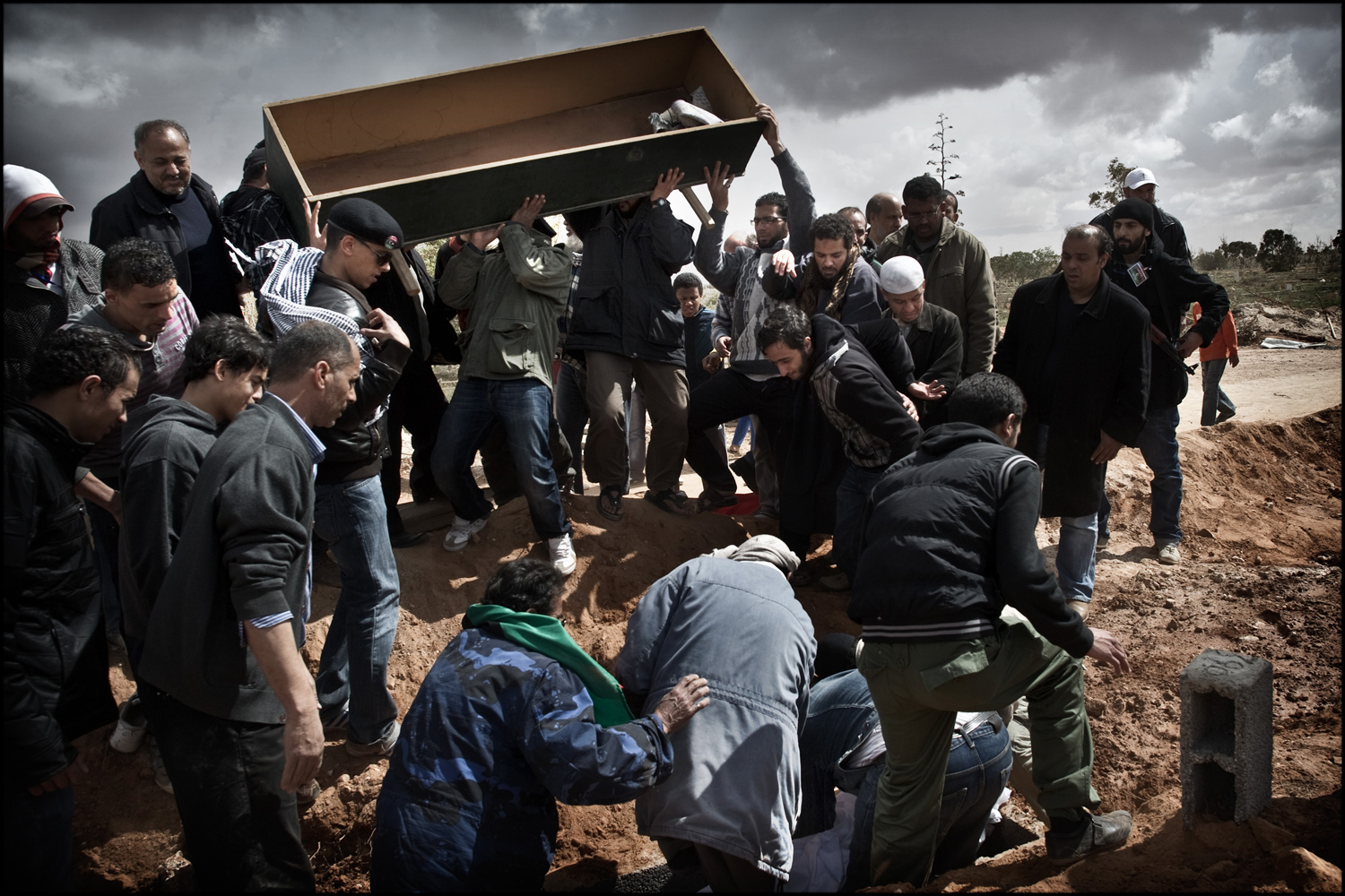March 20, 2011. Libyan men mourn the dead at a funeral near a hospital in the city of Benghazi.