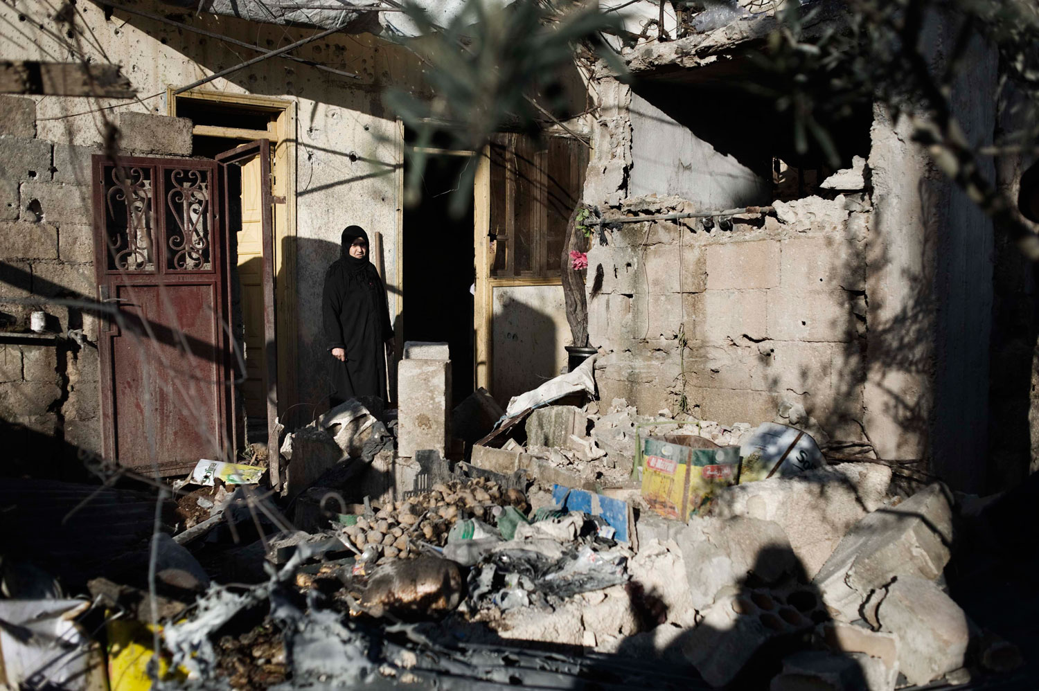 Feb. 9, 2012. A Syrian woman stands among the rubble of her house, destroyed by a Syrian Army mortar, in al-Qsair.